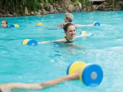 Groep mensen doet fitness oefeningen in het zwembad tijdens Aqua Workout