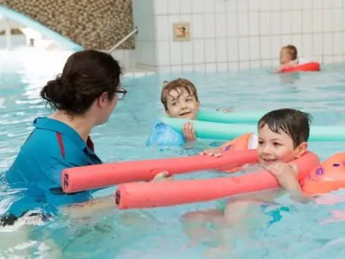 Kind volgt zwemles met instructeur in zwembad